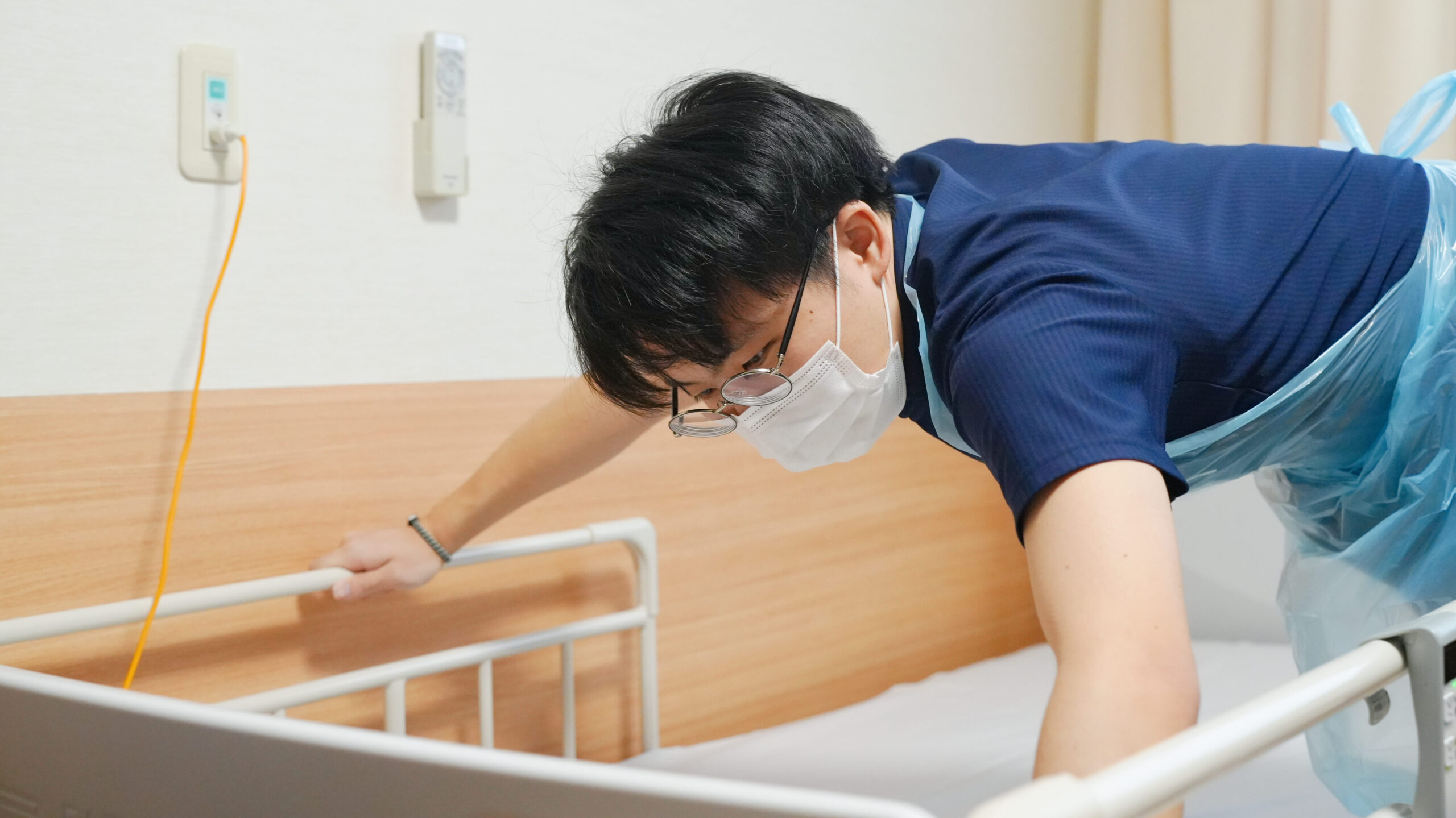 シーツ交換をする男性介護士